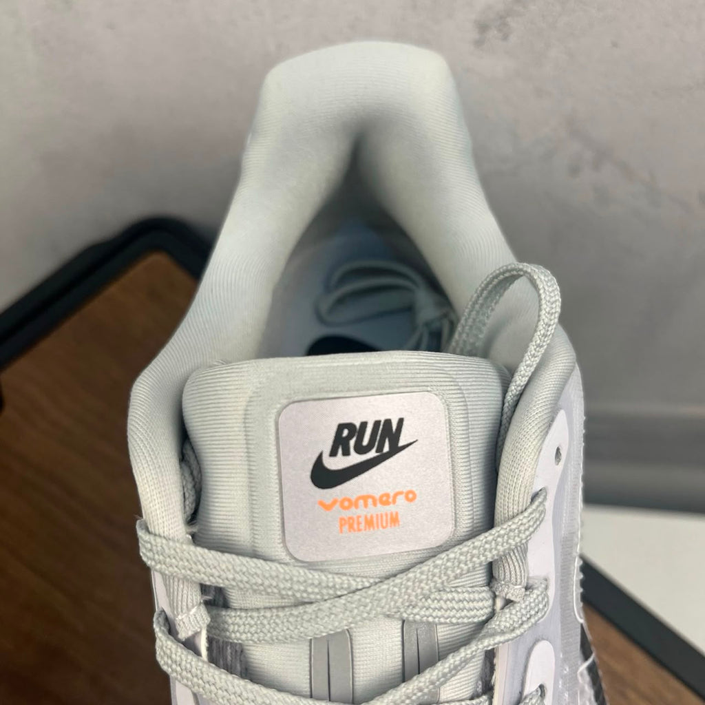 Tênis Nike Zoom Vomero 5 Premium branco e laranja.
